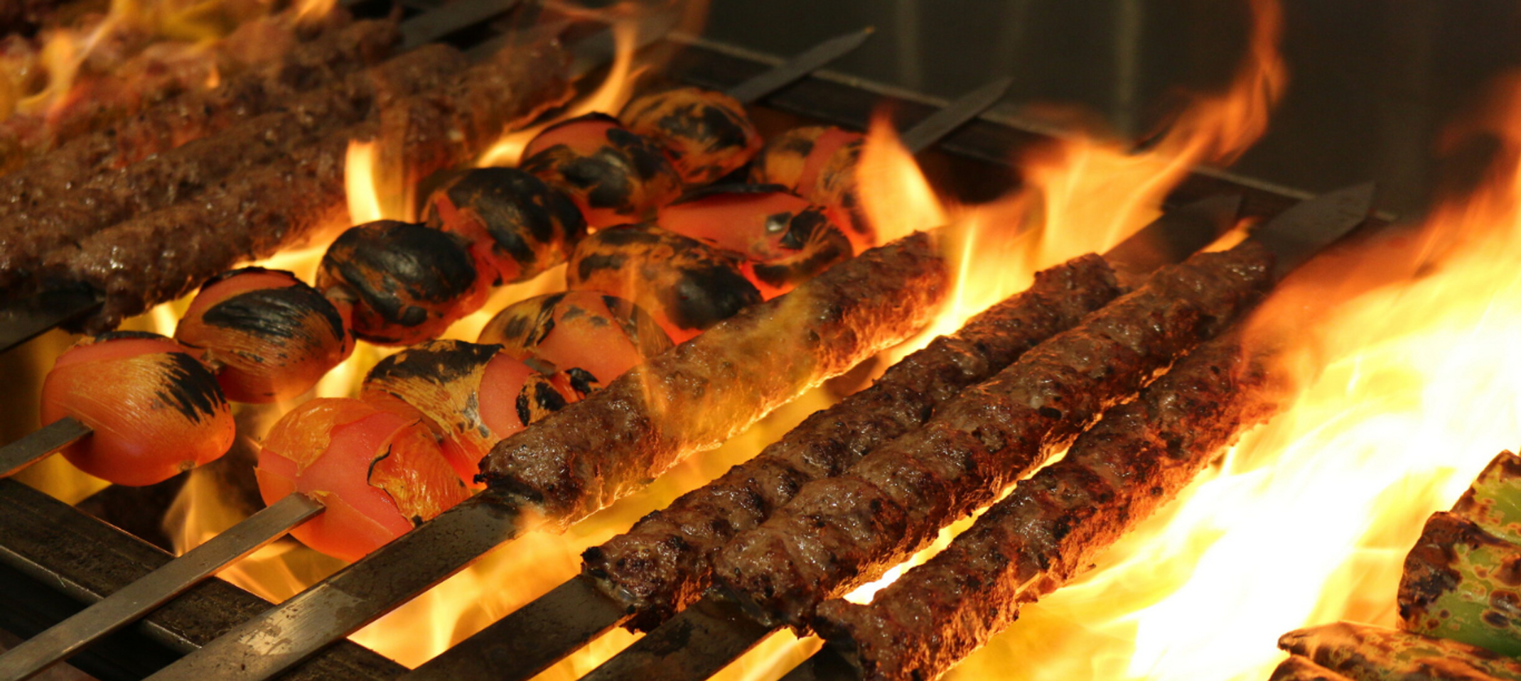 Chicken kebab skewers on a flaming grill